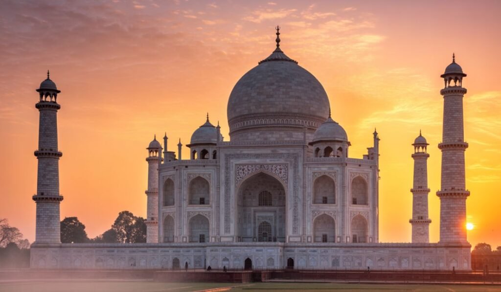 Taj Mahal sunrise view from Mehtab Bagh with golden light and river reflection.